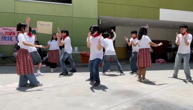 High school students in traditional Filipino costumes dancing at AAPI event at their school
