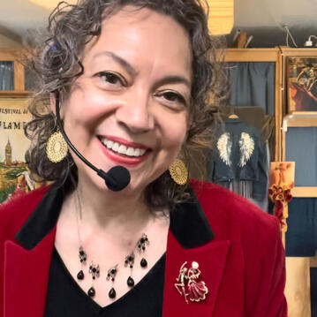 Close up of Miss Coco with headset mic, smiling into Zoom camera.